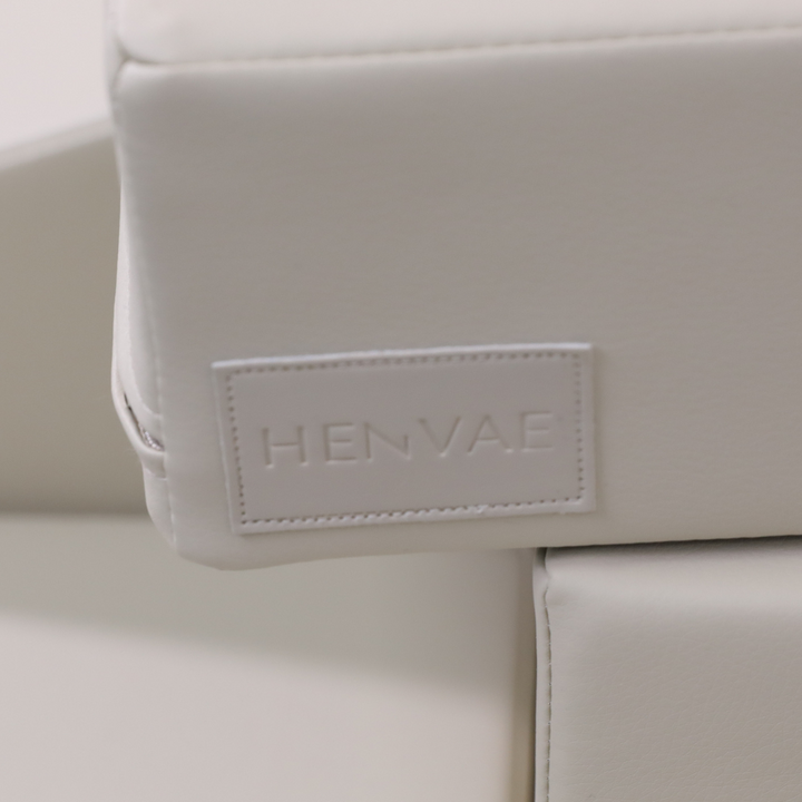 Detail van de beige bekleding van de baby speelset met henvae logo embossed