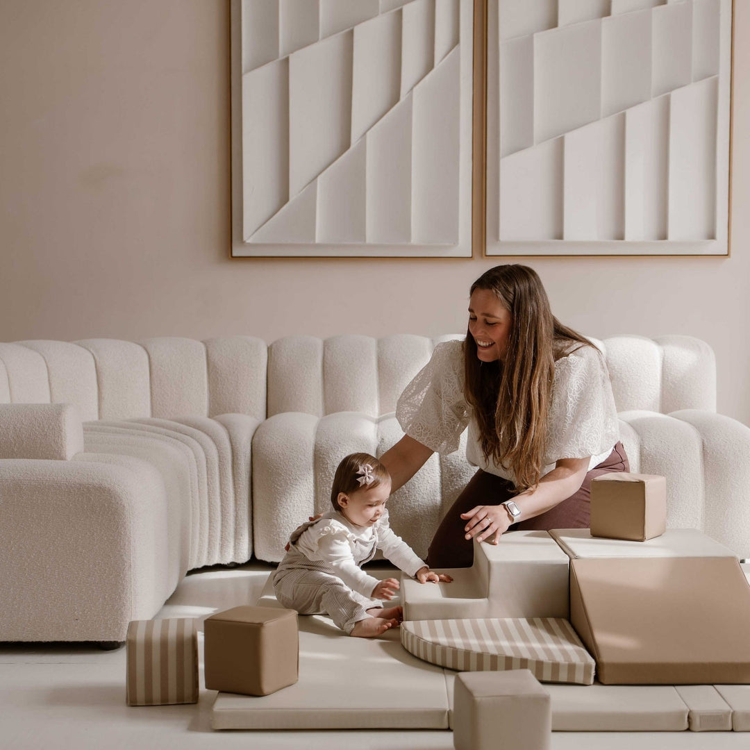 Baby speelt samen met haar moeder op de zachte Sand Stripe speelset van HENVAE