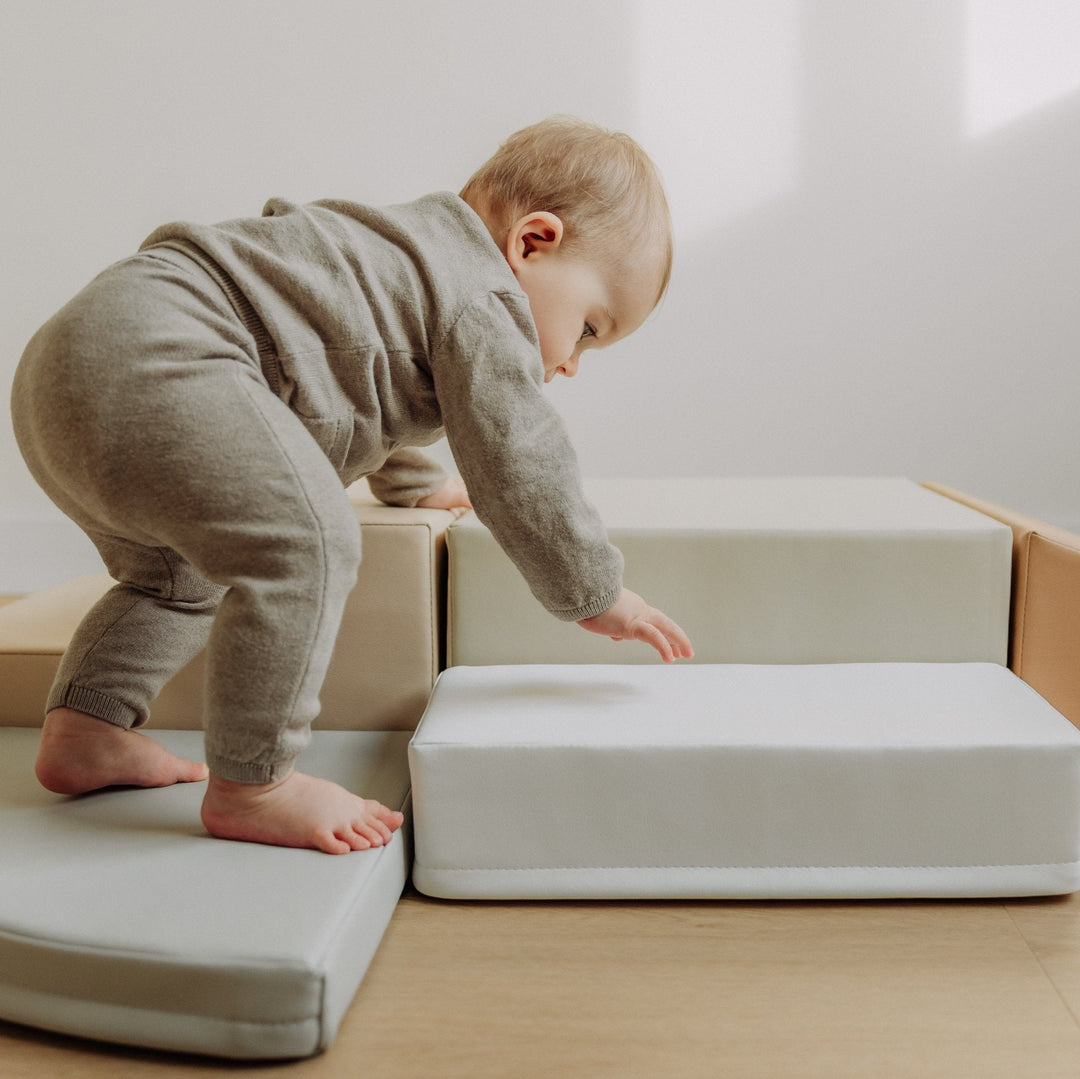 Veilig spelen en leren met de HENVAE® baby klimset. Stevige schuimblokken met premium veganistisch leer voor baby's en jonge peuters. Ideaal om te kruipen, klimmen, rollen en stapelen. Stimuleert motorische vaardigheden, coördinatie, balans en ruimtelijk inzicht. Antislip onderkant voor stabiliteit. Verkrijgbaar in SAND STRIPE, STONE STRIPE, SAND GREY en SQUARE. Duurzaam, zacht en eenvoudig schoon te maken – perfect voor elke speelkamer.  Verjaardagscadeau baby -Speelkussen baby - Klimkussen baby 