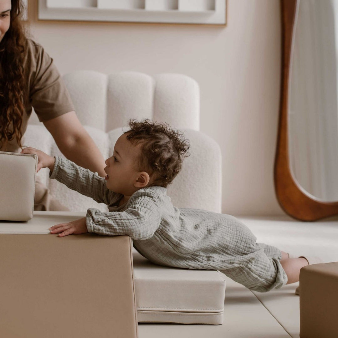 Baby trekt zich op aan de zachte speelblokken van de Stone speelset