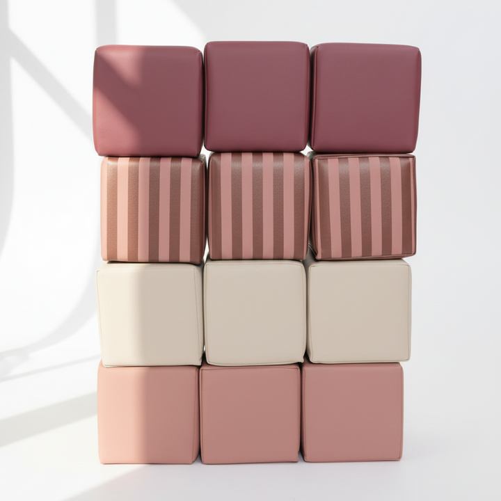 Kind speelt met gestreepte HENVAE stapelblokken in roze, beige, merlot en Merlot Rose.