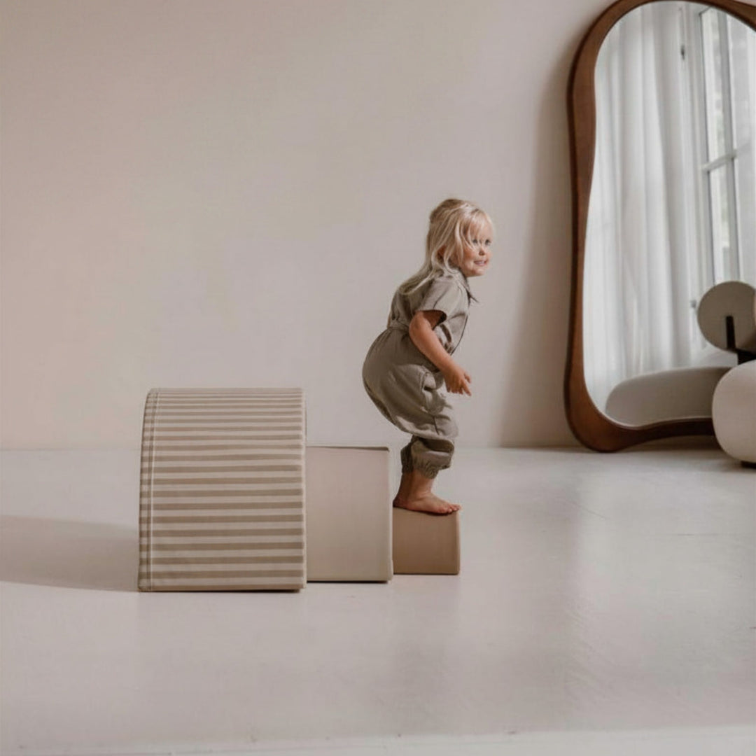 Kind balanceert op de Sand Stripe regenboogbogen van HENVAE
