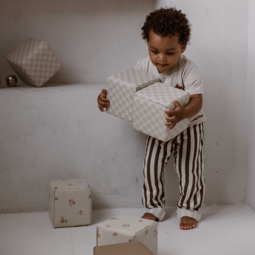 Kind draagt zachte Retro stapelblokken met beige geblokt patroon